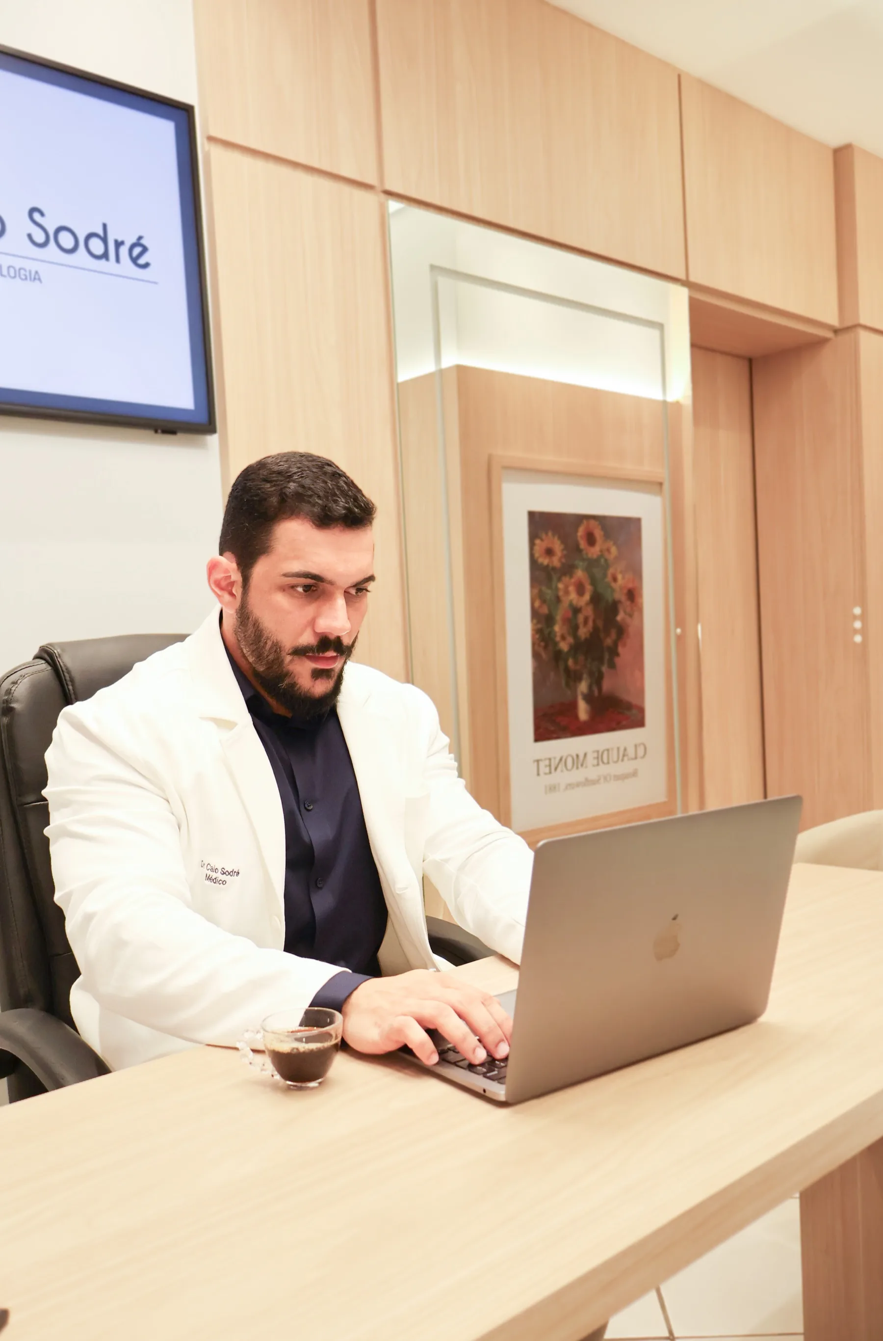 Dr. Caio Sodré analisando informações no consultório